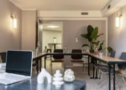 une salle de conférence avec des tables et des chaises et une plante