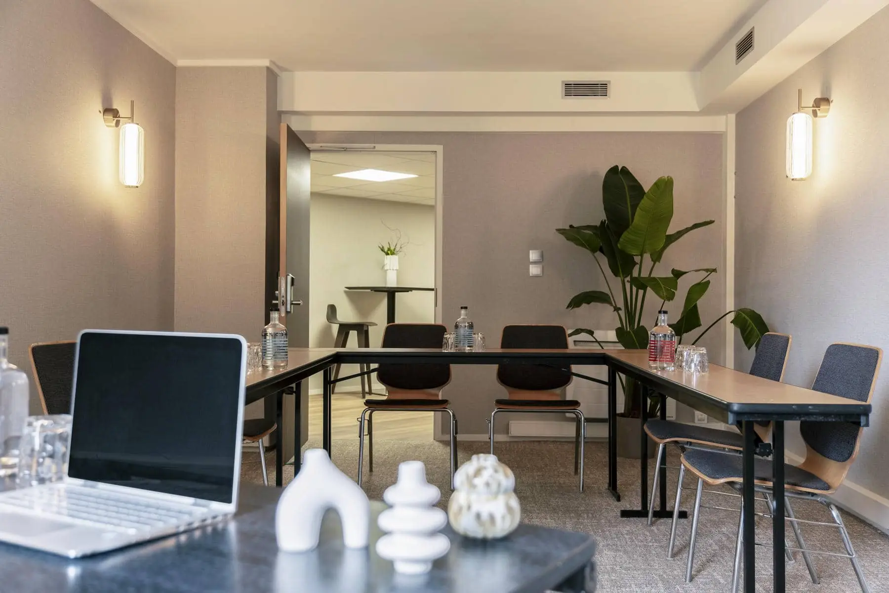 a conference room with tables and chairs and a plant