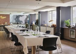 une salle avec des tables et des chaises et un panneau indiquant cappuccino