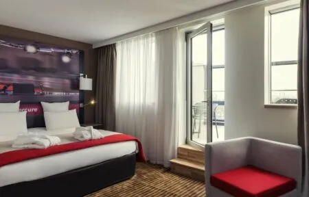 une chambre d'hôtel mercure avec un lit et une chaise