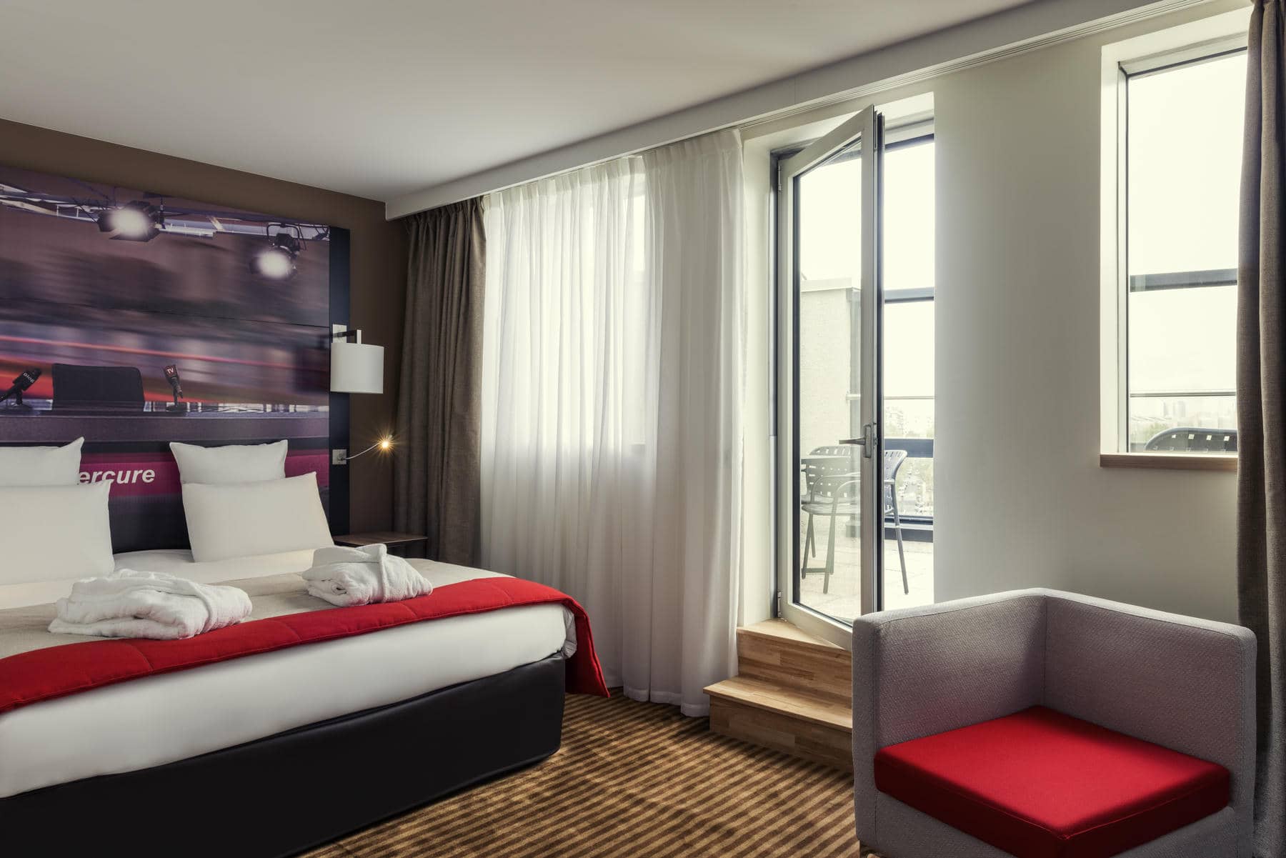 une chambre d'hôtel mercure avec un lit et une chaise