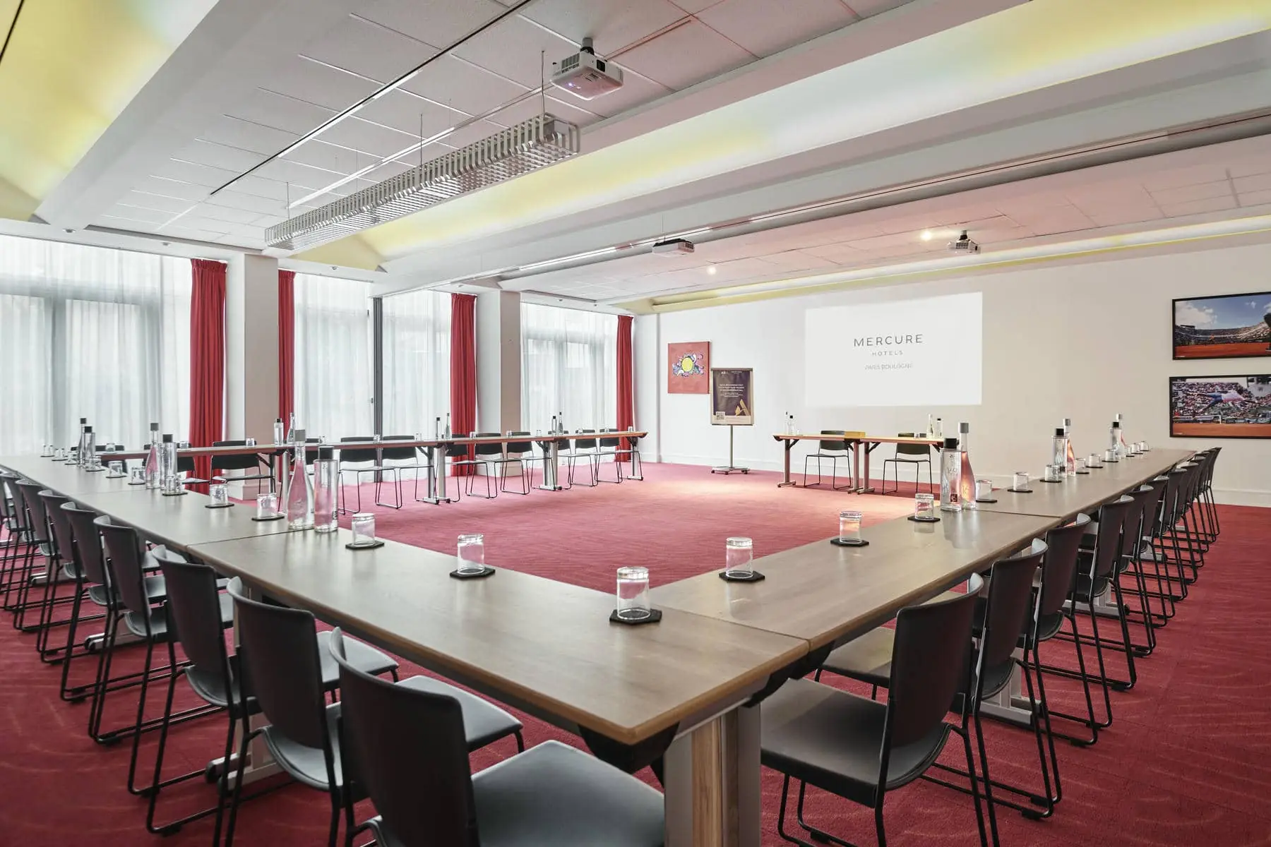 une salle de conférence mercure avec de longues tables et chaises
