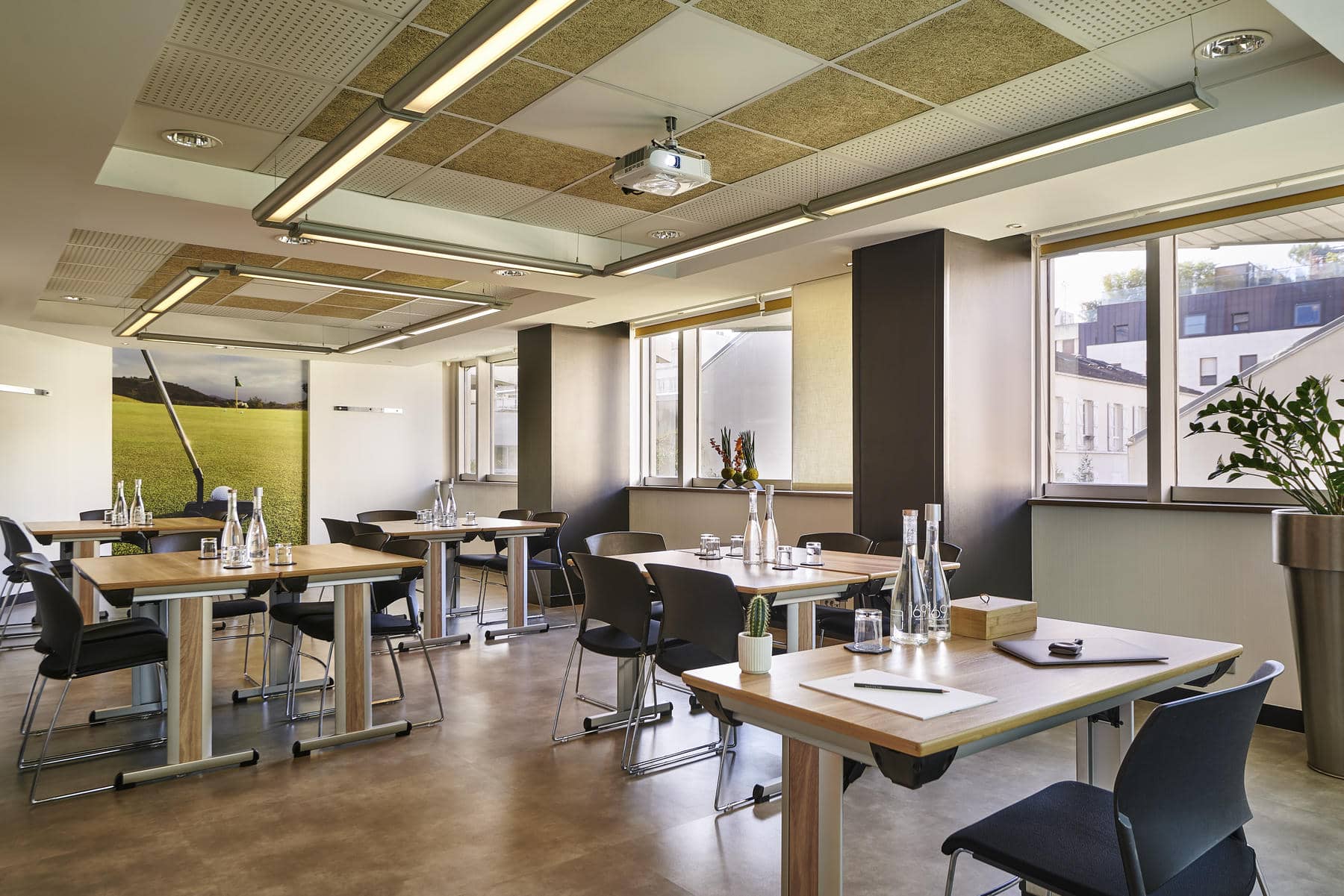 une salle de conférence avec tables et chaises et un projecteur