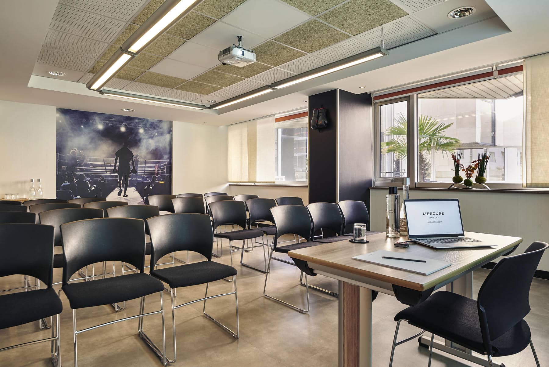 une salle de conférence avec un ordinateur portable et un panneau indiquant mercure