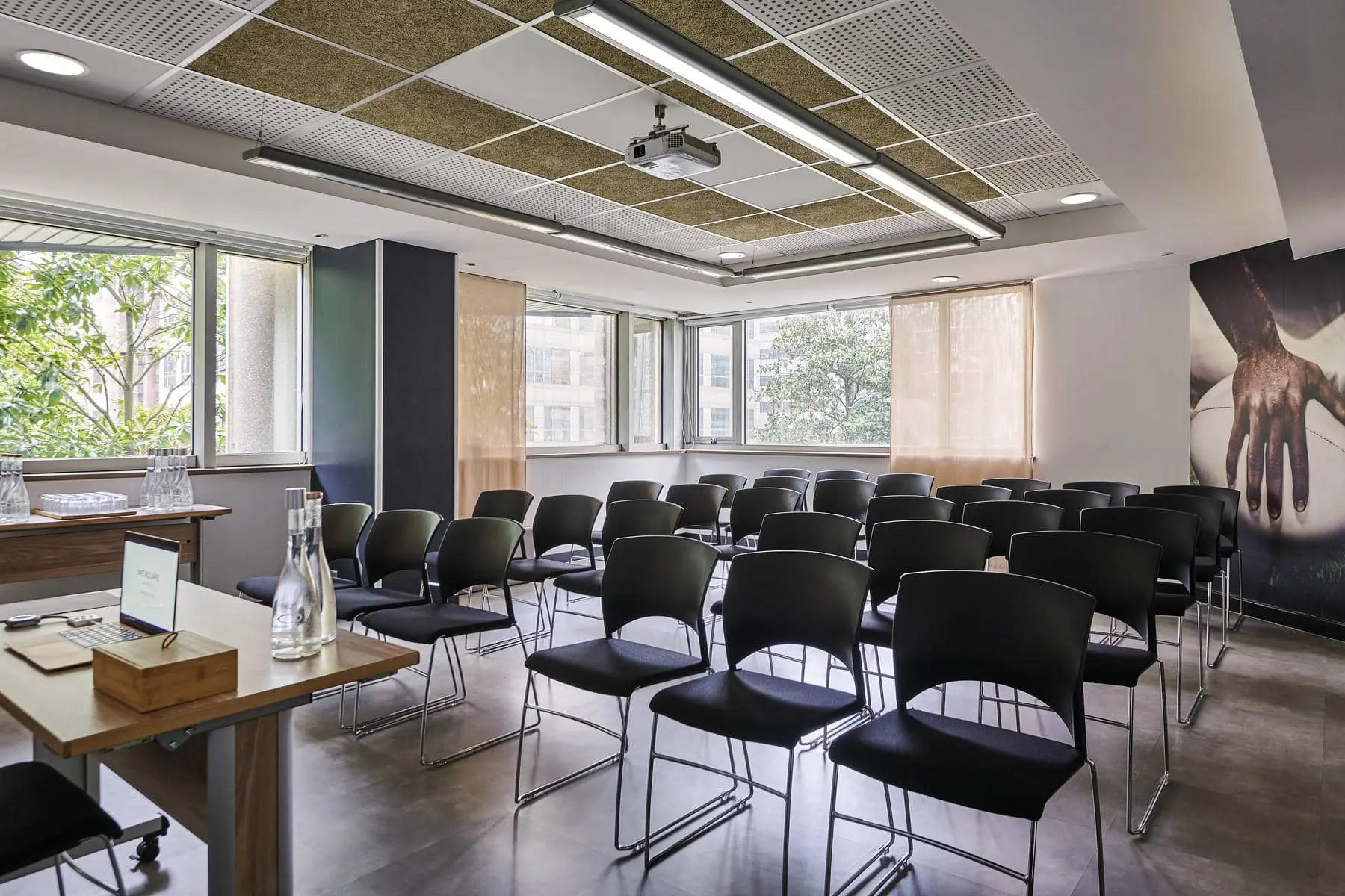 une salle de conférence avec des chaises noires et un projecteur