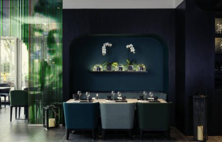 un restaurant avec des chaises vertes et un mur bleu