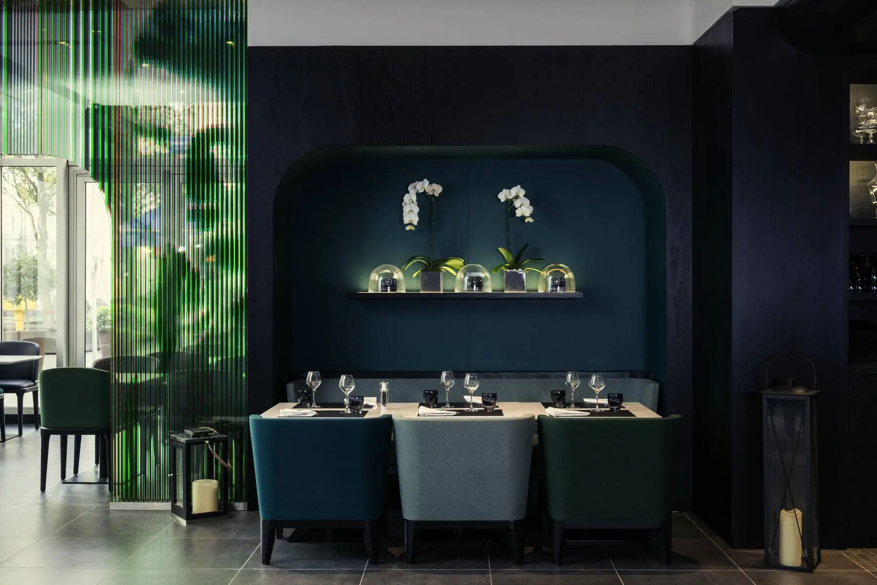 un restaurant avec des chaises vertes et un mur bleu