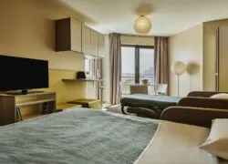 une chambre avec deux lits et une télévision à écran plat