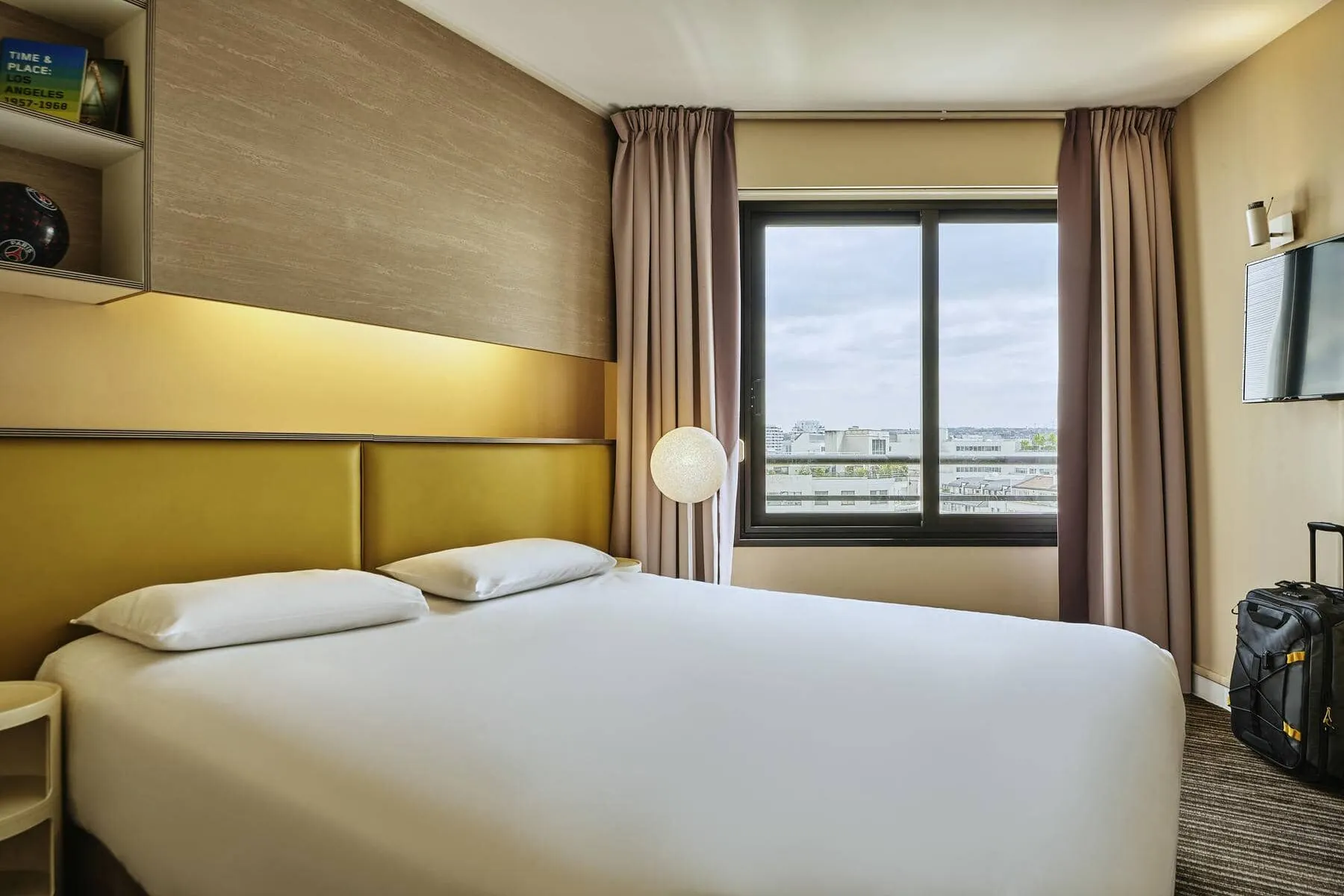 a hotel room with a king size bed and a window