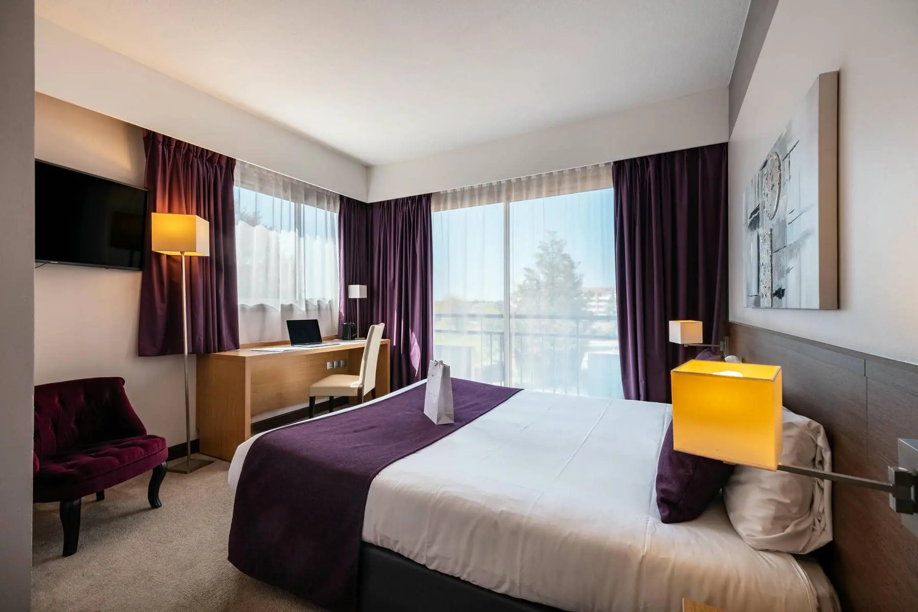 une chambre d'hôtel avec un grand lit et des rideaux violets