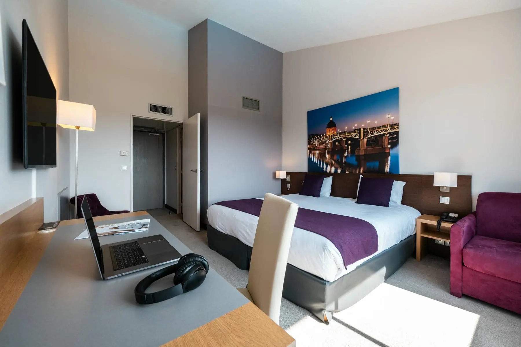 une chambre d'hôtel avec un grand tableau sur le mur au-dessus du lit