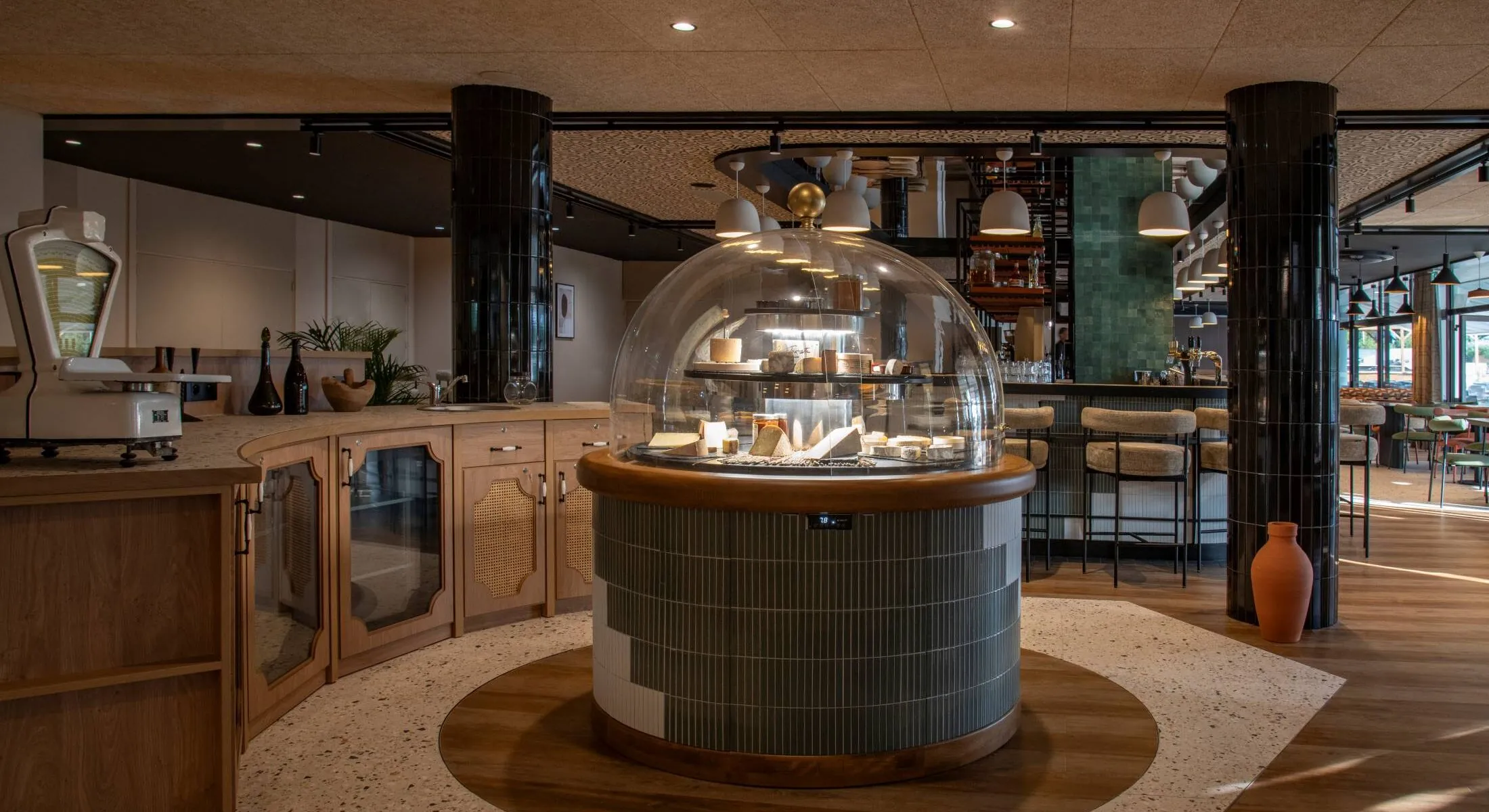 un restaurant avec un étalage de fromages sous un dôme