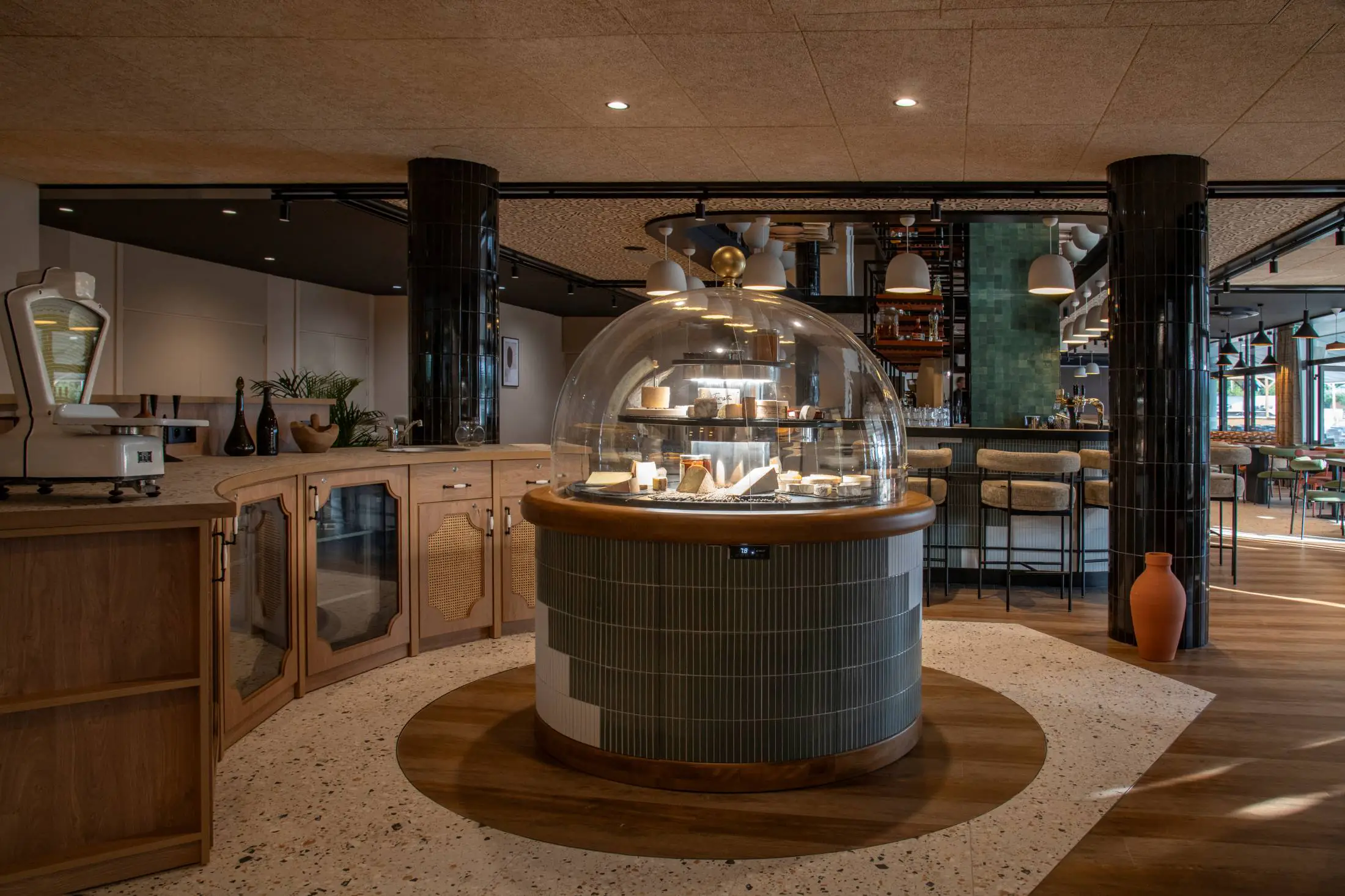 un restaurant avec un étalage de fromages sous un dôme