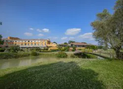 un pont au-dessus d'une étendue d'eau avec un grand bâtiment à l'arrière-plan