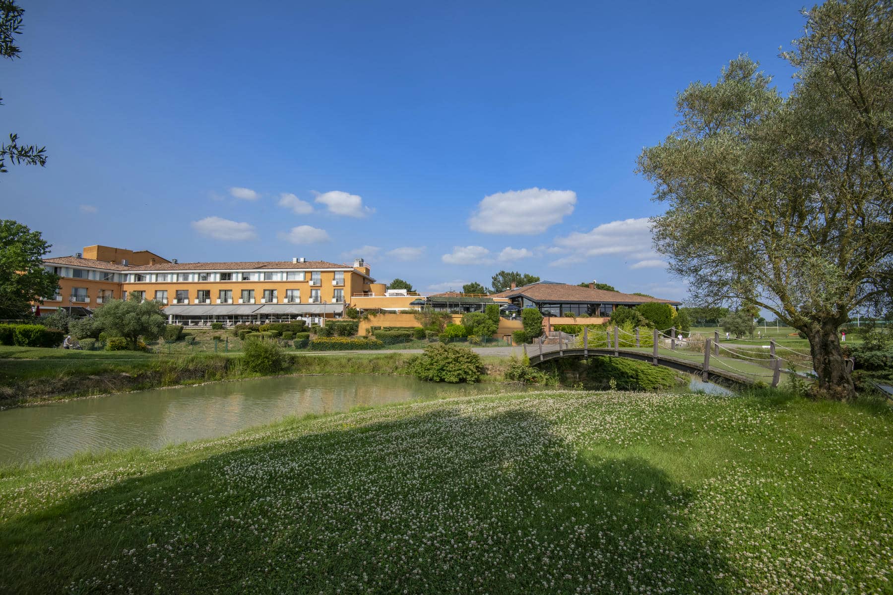 un pont au-dessus d'une étendue d'eau avec un grand bâtiment à l'arrière-plan