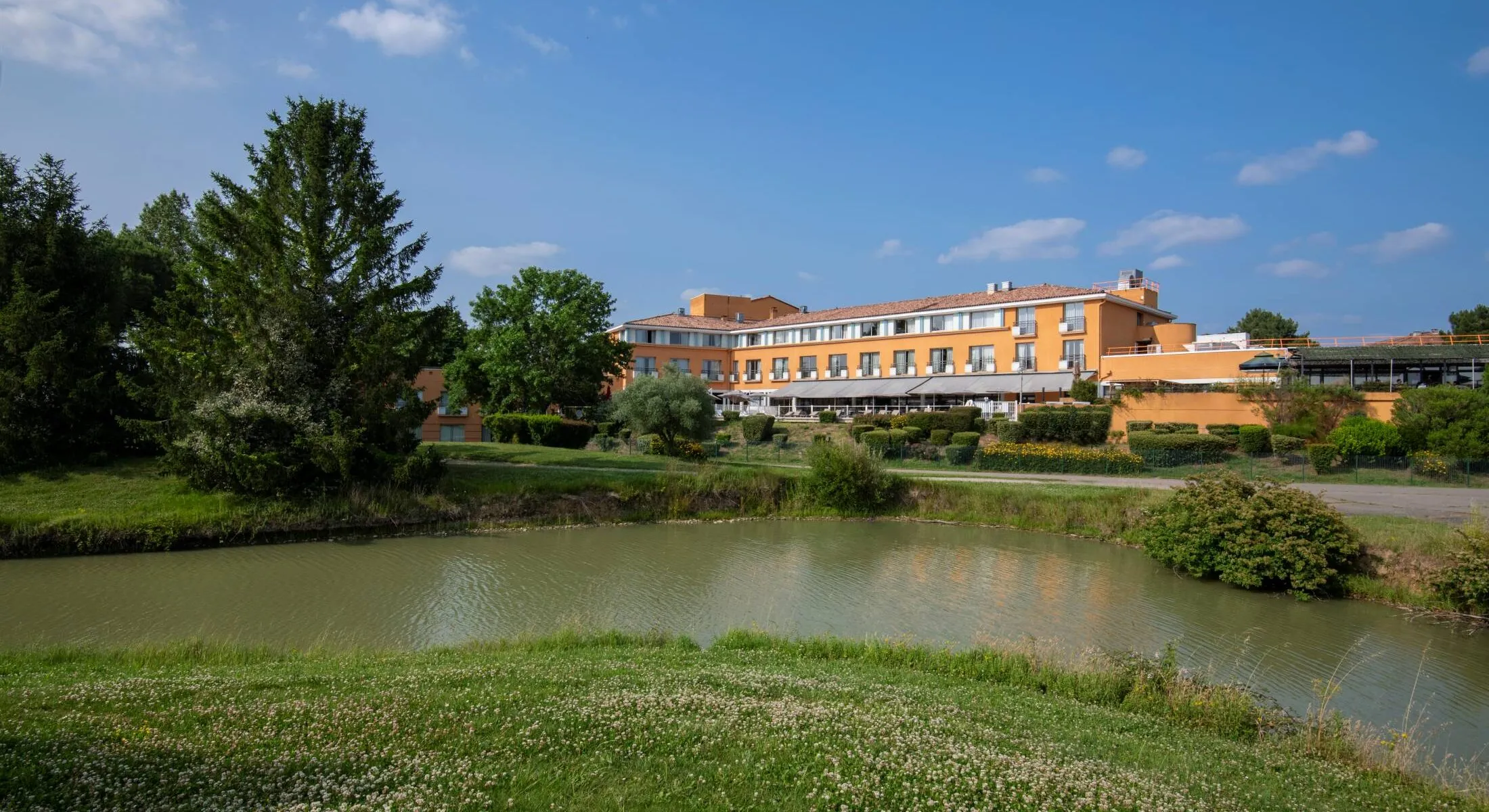 un grand bâtiment orange se trouve à côté d'une étendue d'eau