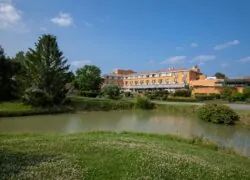 un grand bâtiment orange se trouve à côté d'une étendue d'eau