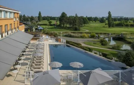 une grande piscine entourée de parasols et de chaises