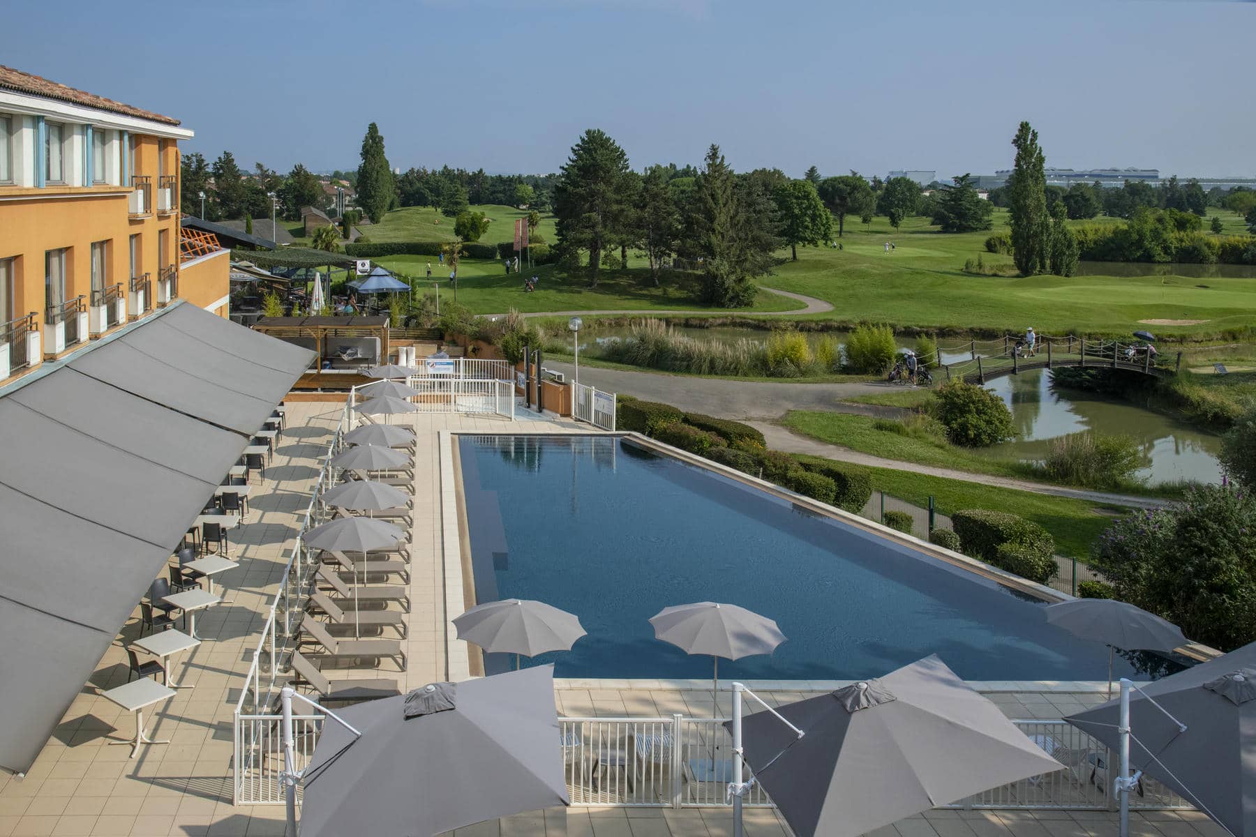 une grande piscine entourée de parasols et de chaises