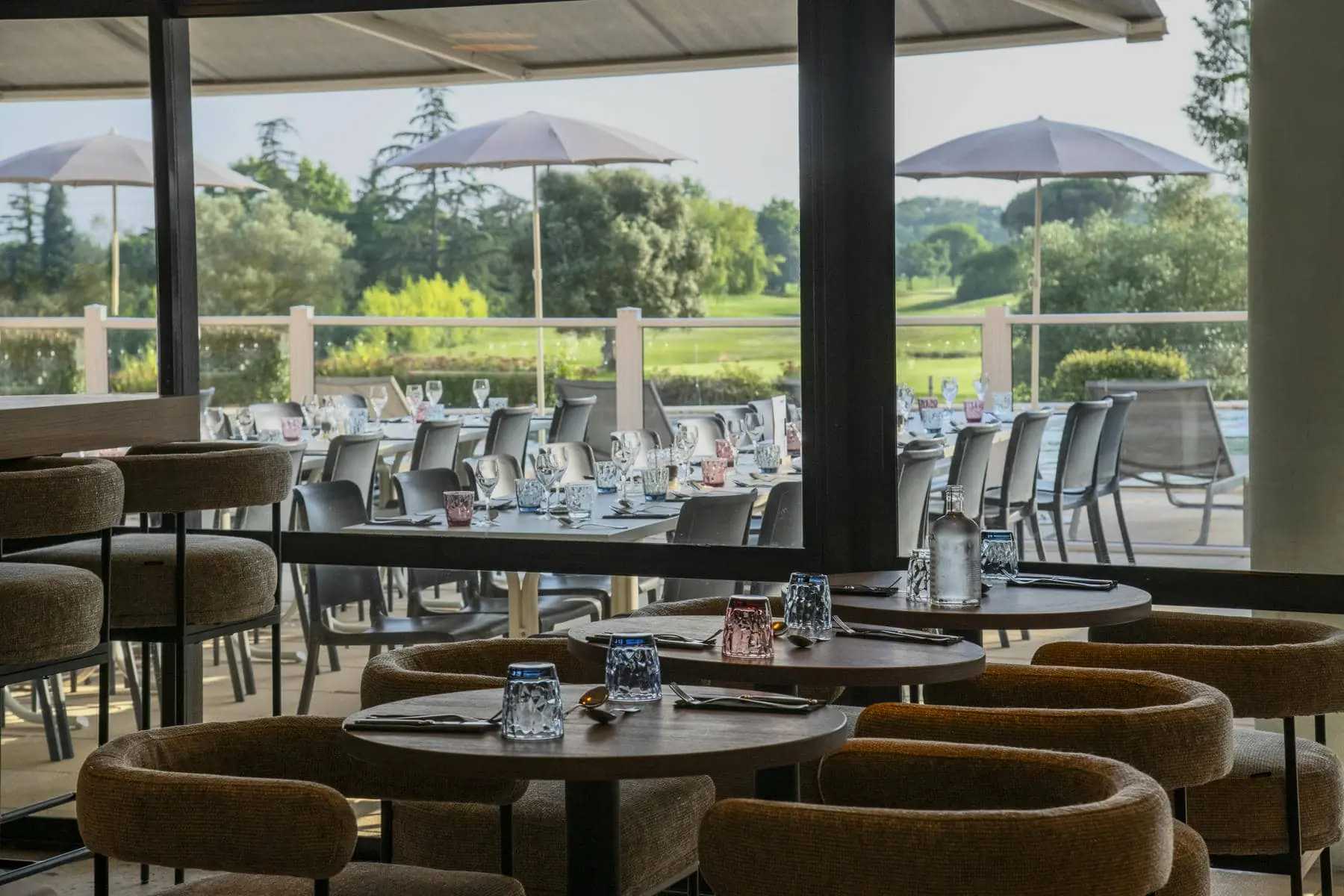 tables et chaises dans un restaurant avec vue sur un terrain de golf