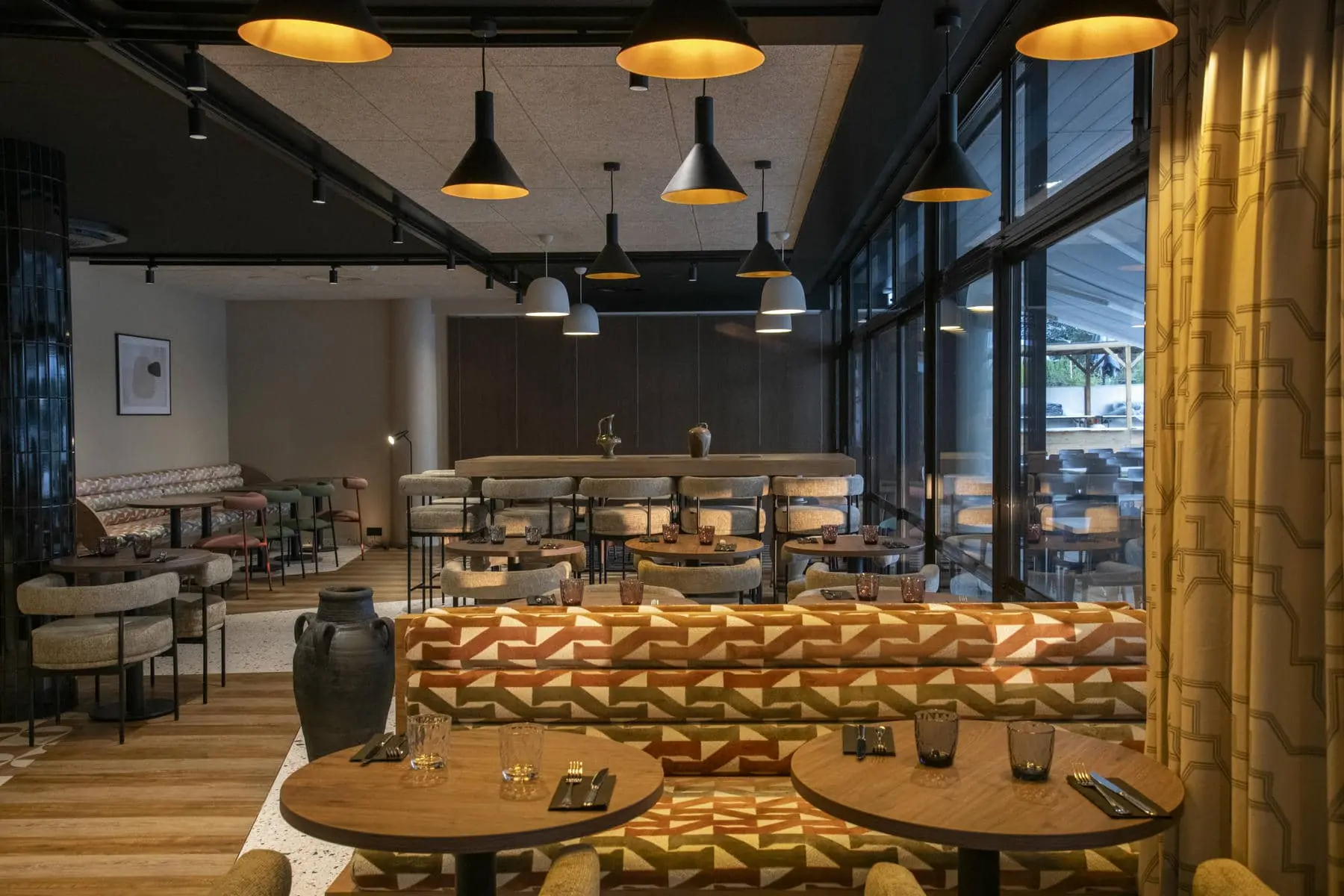 un restaurant avec des tables et des chaises et une grande fenêtre