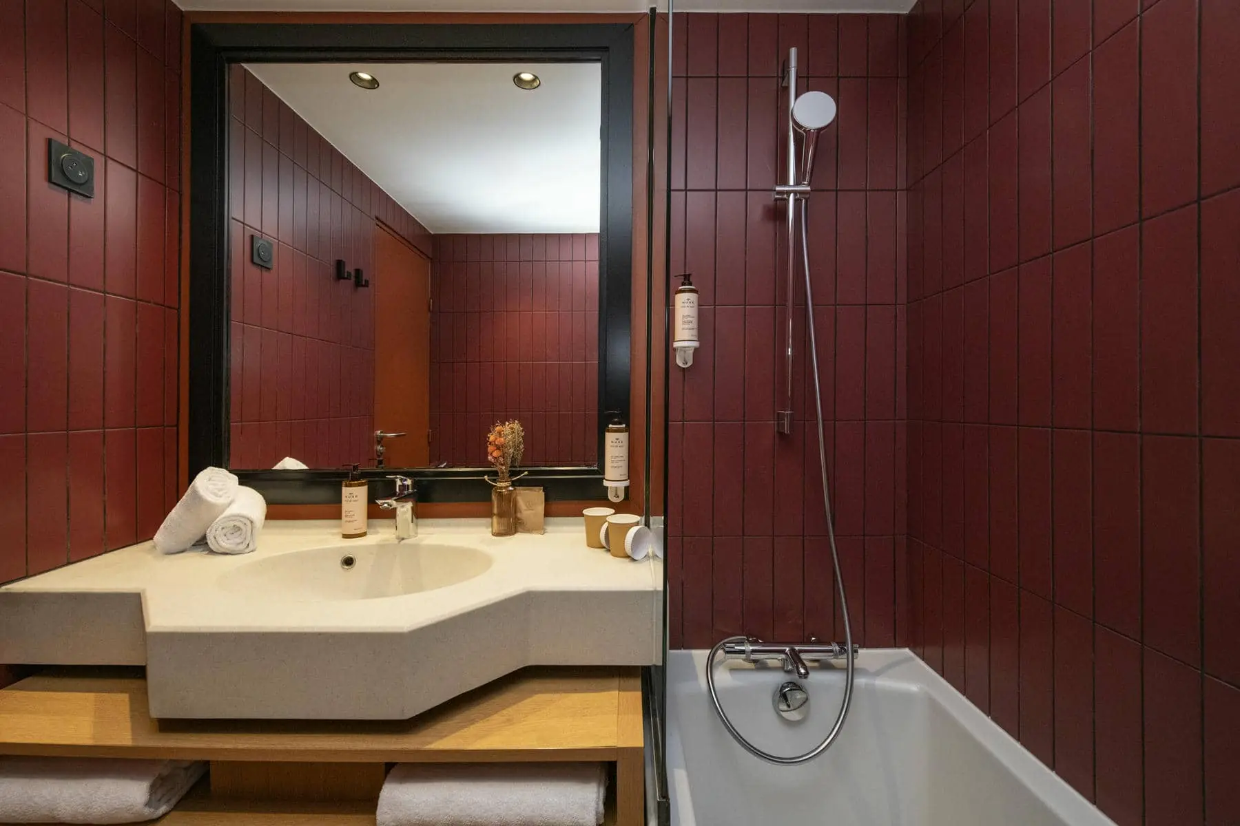 une salle de bains avec des carreaux rouges, un lavabo et une baignoire