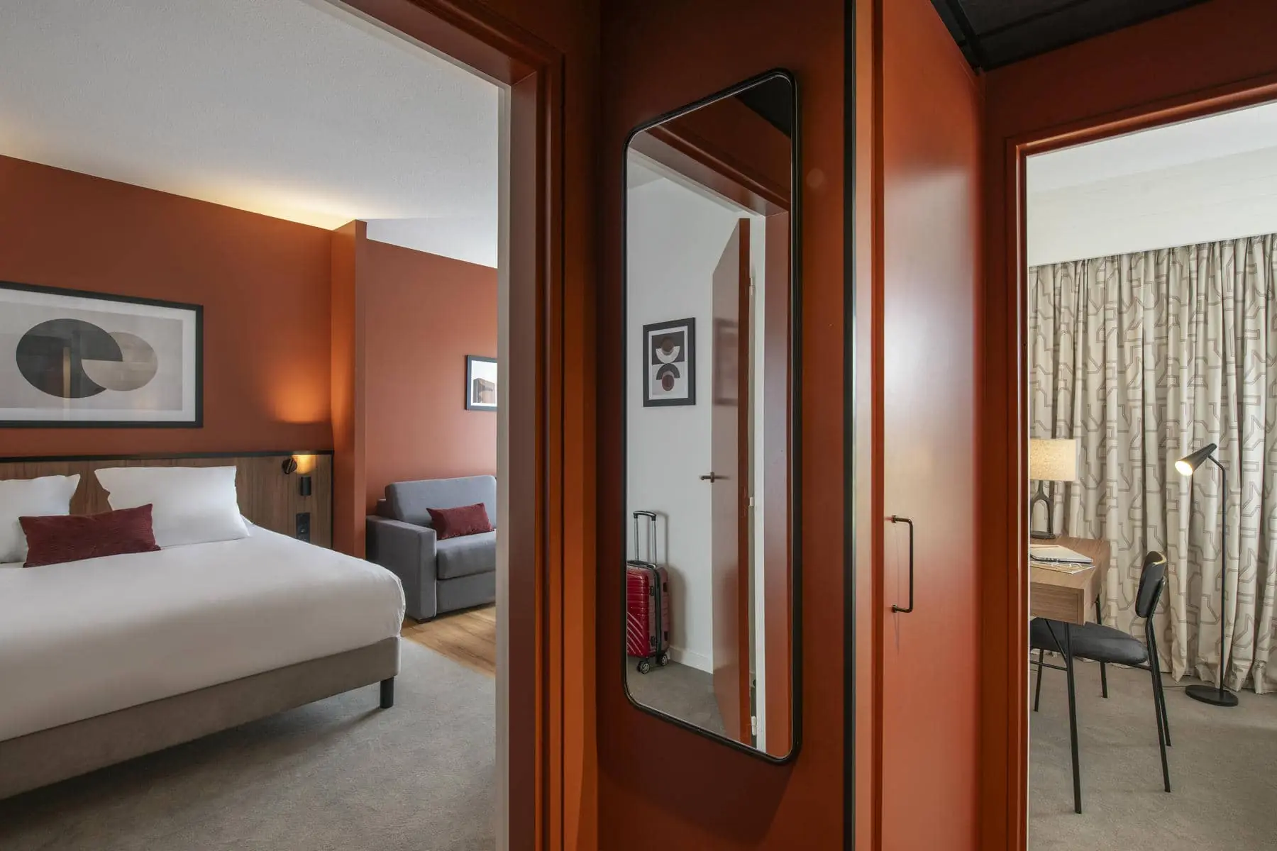 une chambre d'hôtel aux murs rouges avec un grand miroir