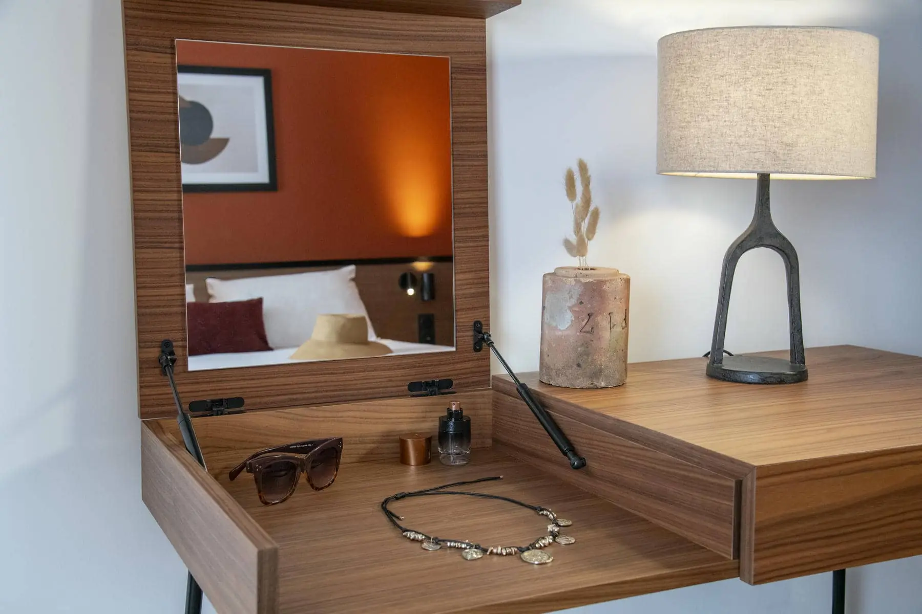 un meuble en bois avec un miroir et une lampe