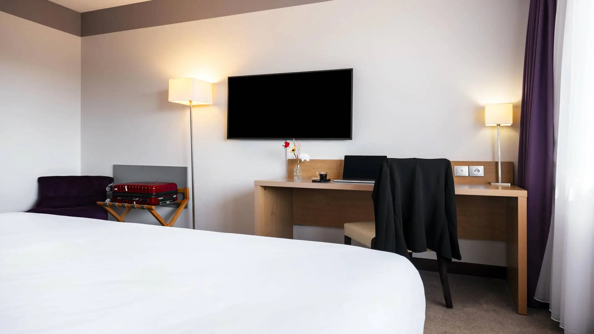Chambre avec lit double face à un bureau et un support à bagages dans l’hôtel séminaire Mercure Toulouse Aéroport Golf de Seilh.