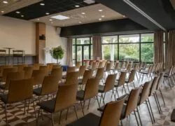 des rangées de chaises sont alignées dans une pièce dotée de nombreuses fenêtres