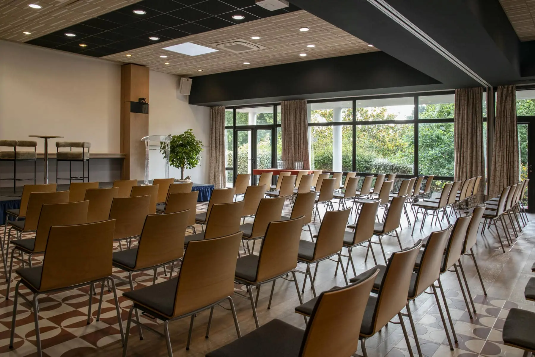 des rangées de chaises sont alignées dans une pièce dotée de nombreuses fenêtres