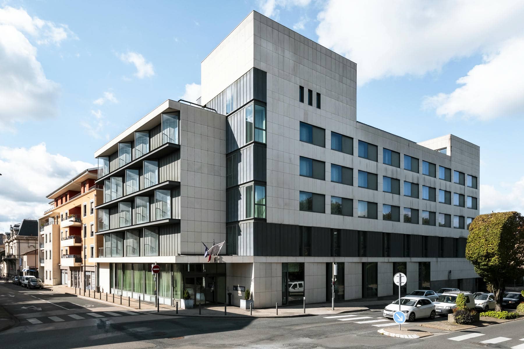 un bâtiment avec de nombreuses fenêtres et un panneau indiquant l'interdiction de stationner