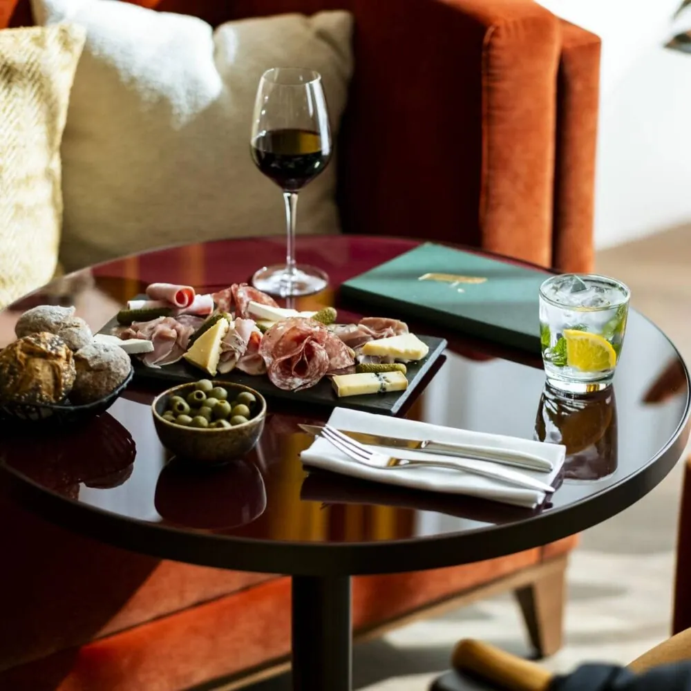une table avec une assiette de nourriture et un verre de vin