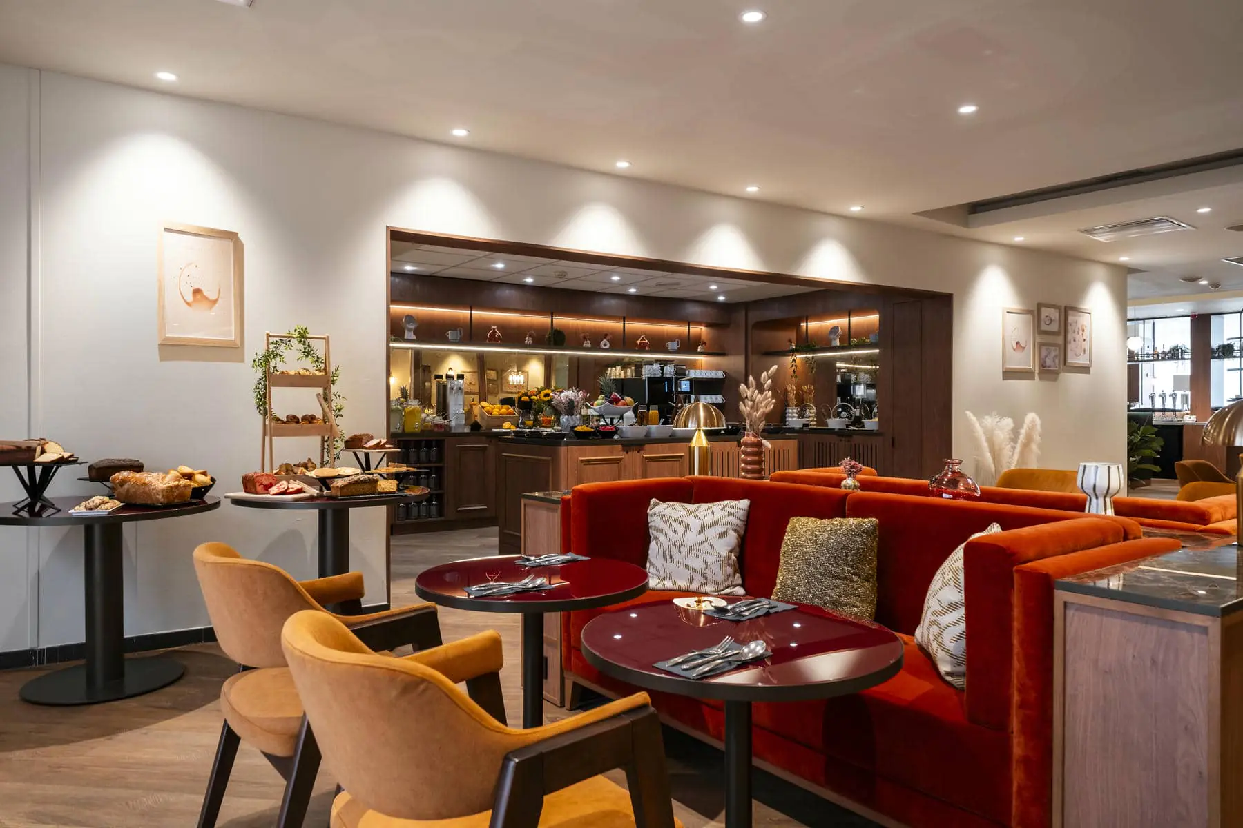 un restaurant avec des tables et des chaises et un canapé rouge