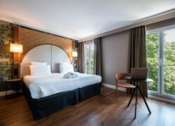 une chambre d'hôtel avec un grand lit et un ordinateur portable sur une table