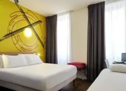 une chambre d'hôtel avec un mur jaune et un lit
