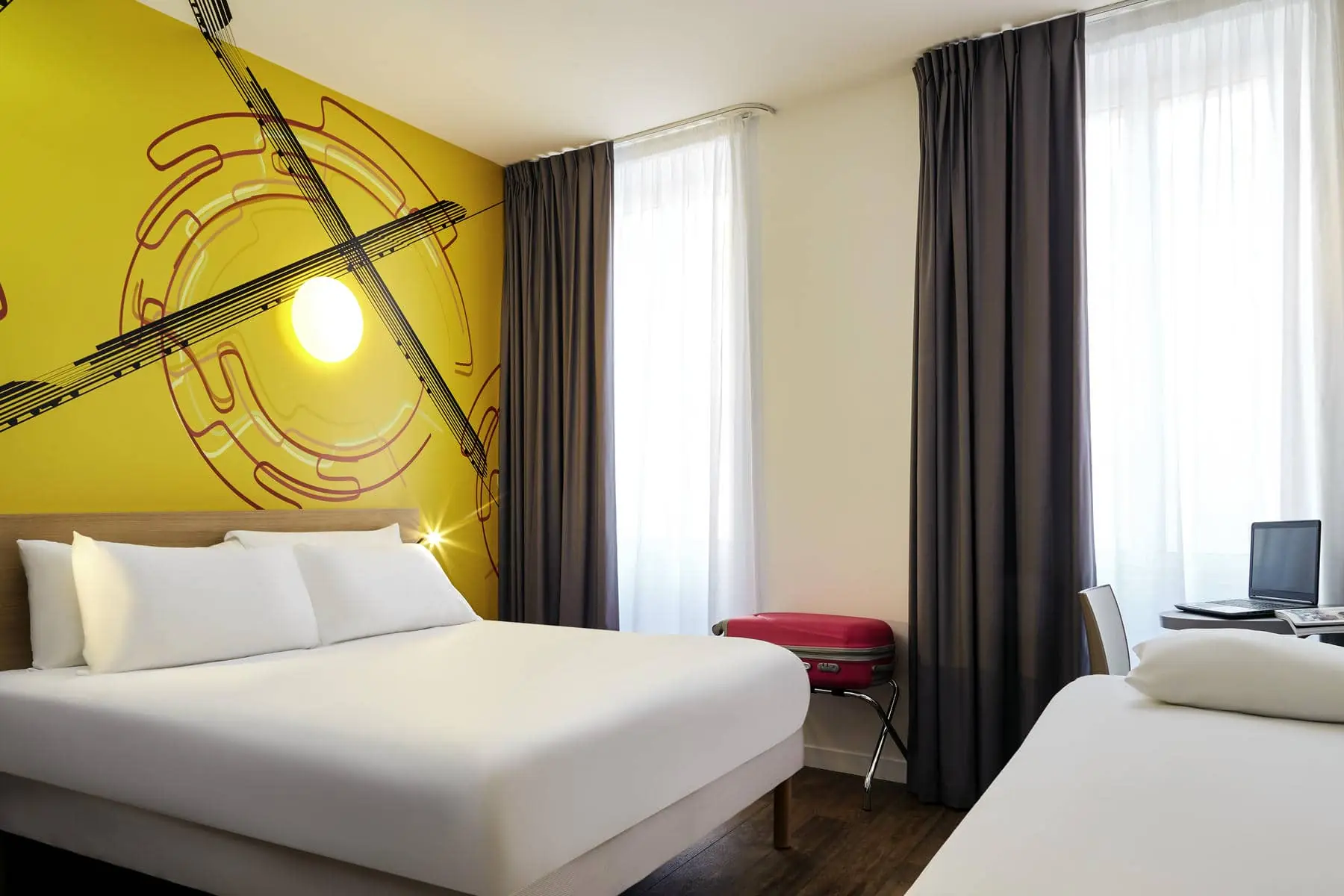 une chambre d'hôtel avec un mur jaune et un lit