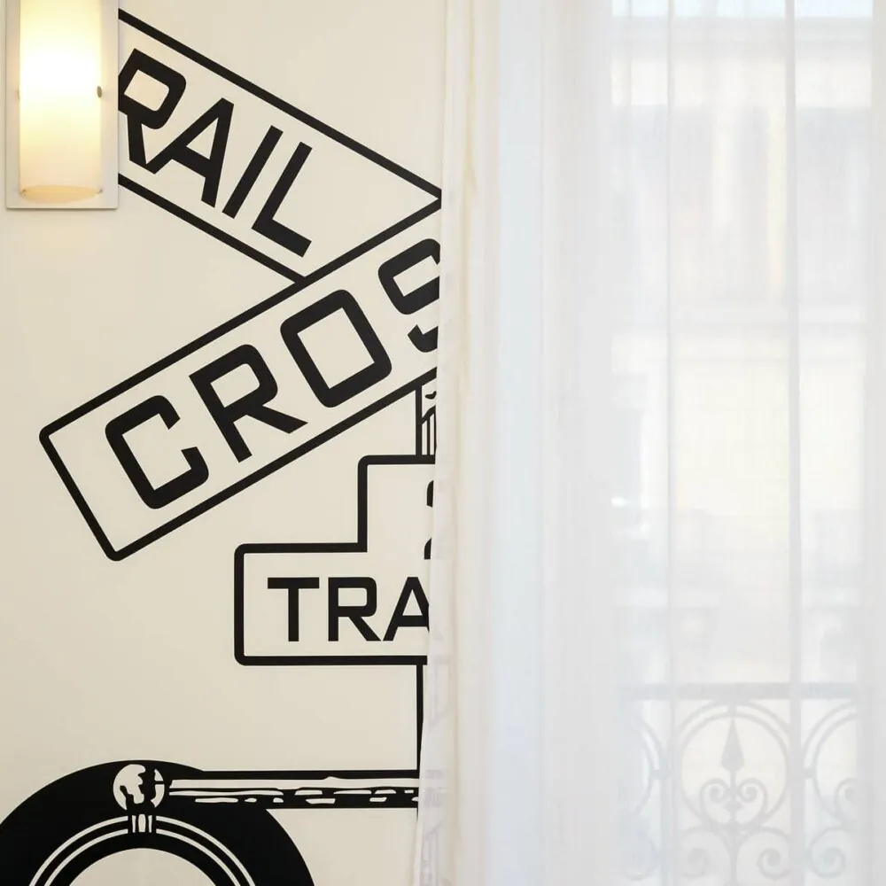 un panneau de passage à niveau est peint sur un mur blanc