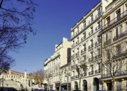 une rangée d'immeubles avec des balcons et une enseigne sur laquelle on peut lire " pharmacie