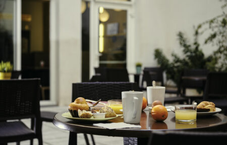 a table with a plate of food and a cup of orange juice