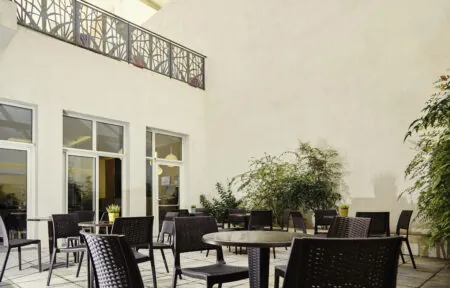 un patio avec tables et chaises et un balcon