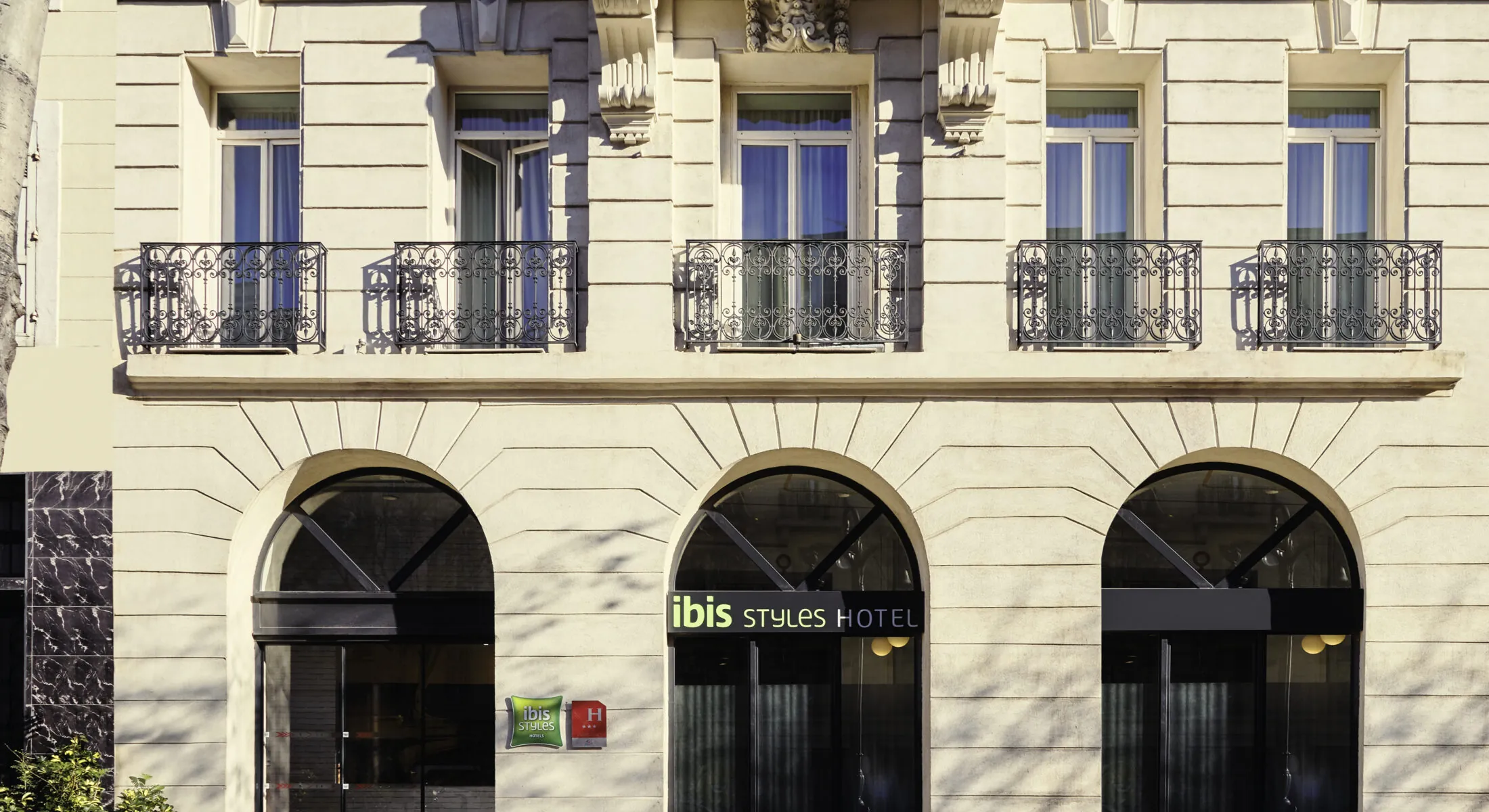 la façade d'un hôtel ibis styles avec des fenêtres cintrées