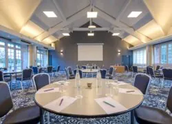 une salle de conférence avec des tables et des chaises et un écran de projection