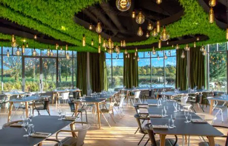 un restaurant avec des tables et des chaises et un plafond vert