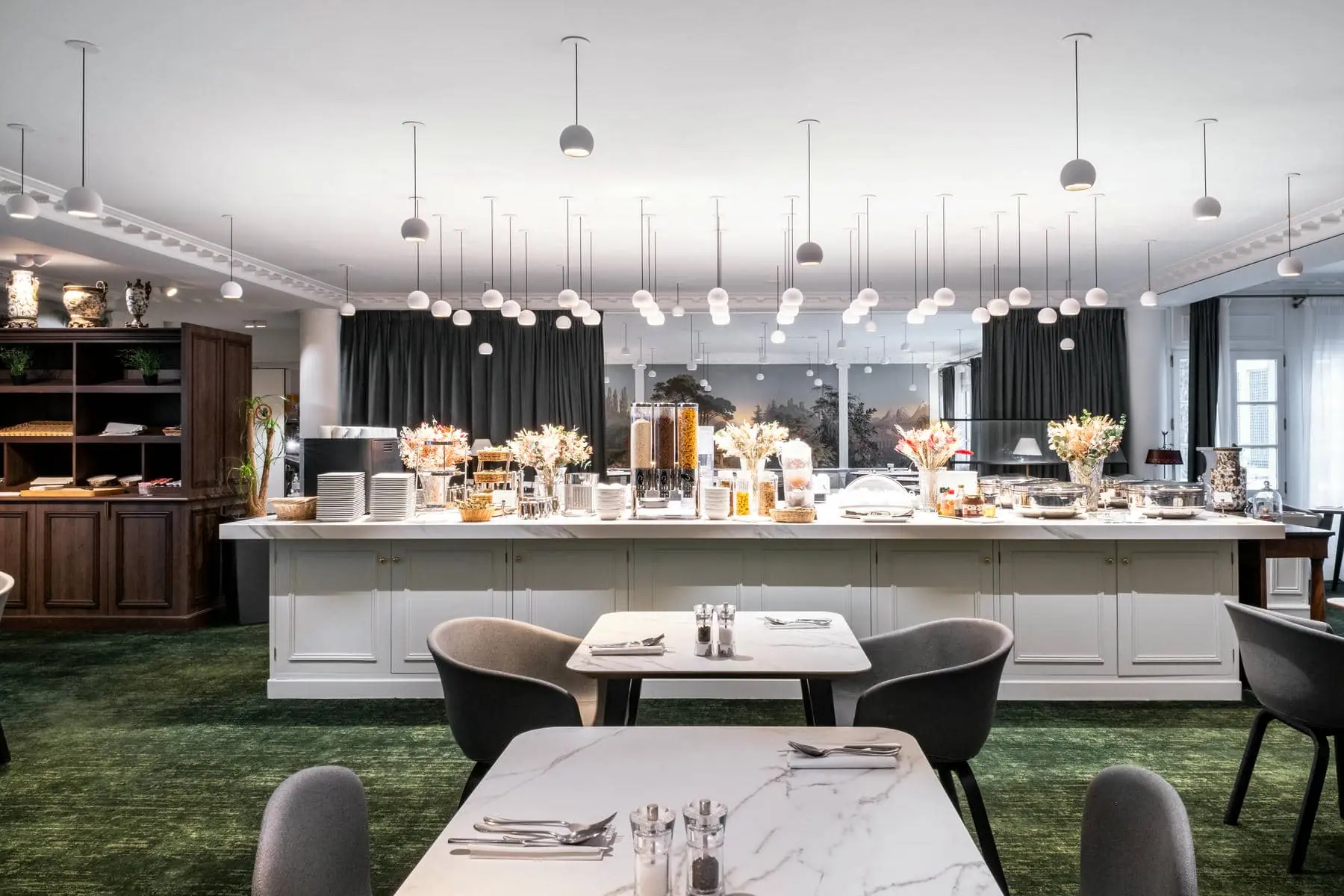 a dining room with tables and chairs and a buffet