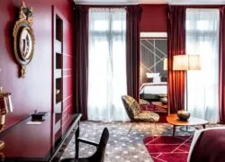 a hotel room with red curtains and a large mirror