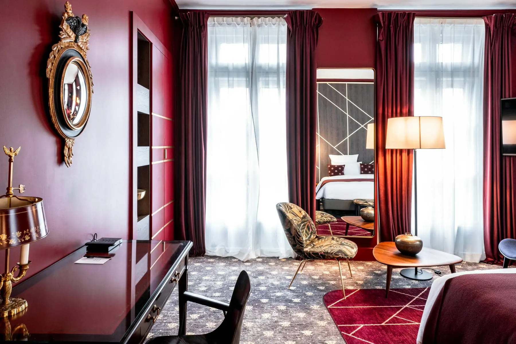 a hotel room with red curtains and a large mirror