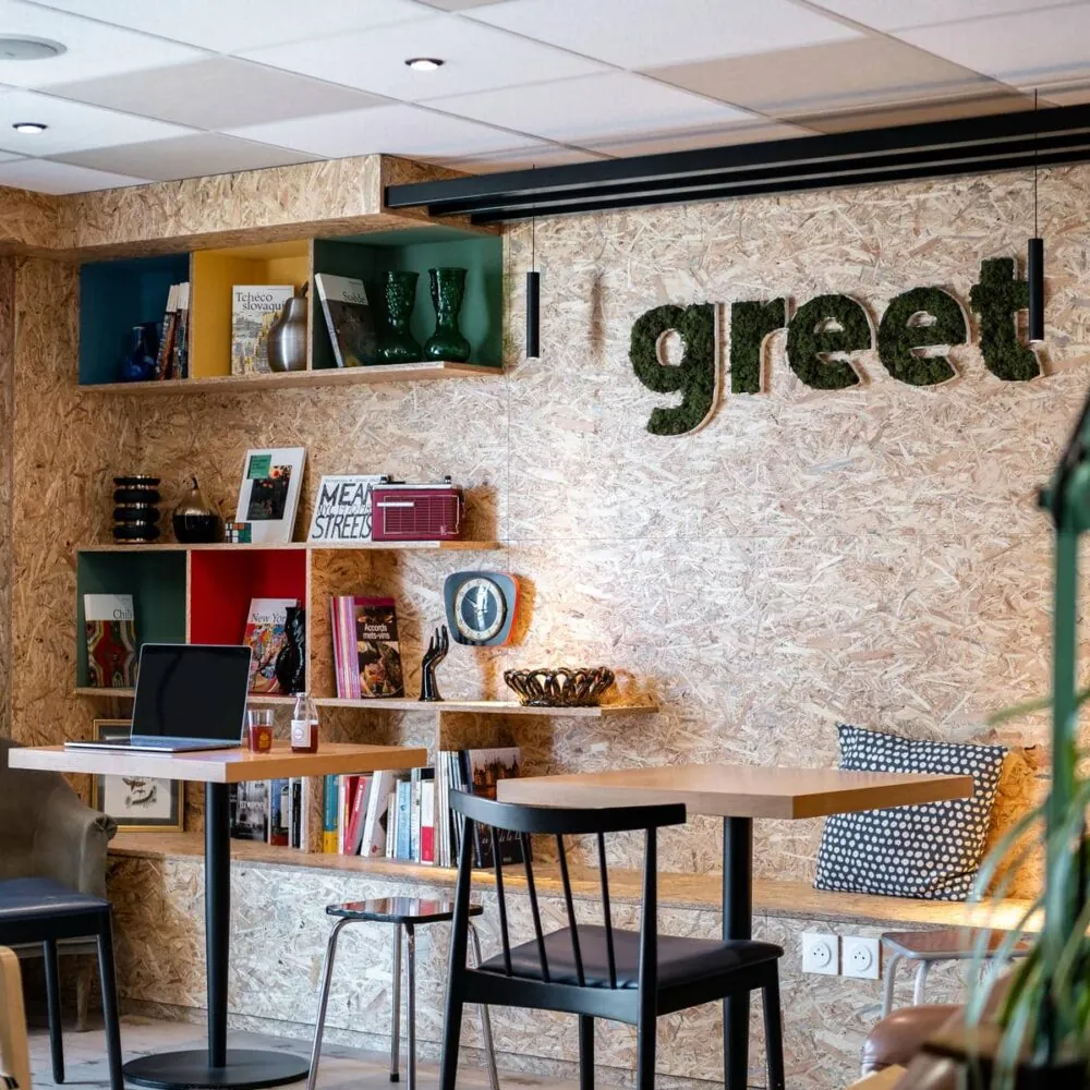 une salle avec des tables et des chaises et un mur sur lequel est écrit "je salue"