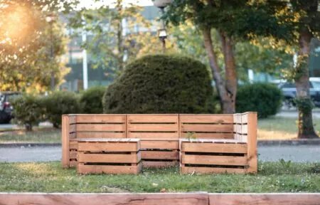 un banc en bois est posé dans l'herbe d'un parc