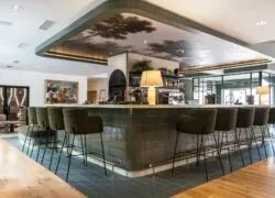 un bar avec une peinture d'arbres au plafond